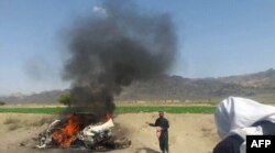 FILE: A car is seen on fire at the site of a drone strike believed to have killed Afghan Taliban leader Mullah Akhtar Mohammad Mansur in southwestern Pakistan on May 21.