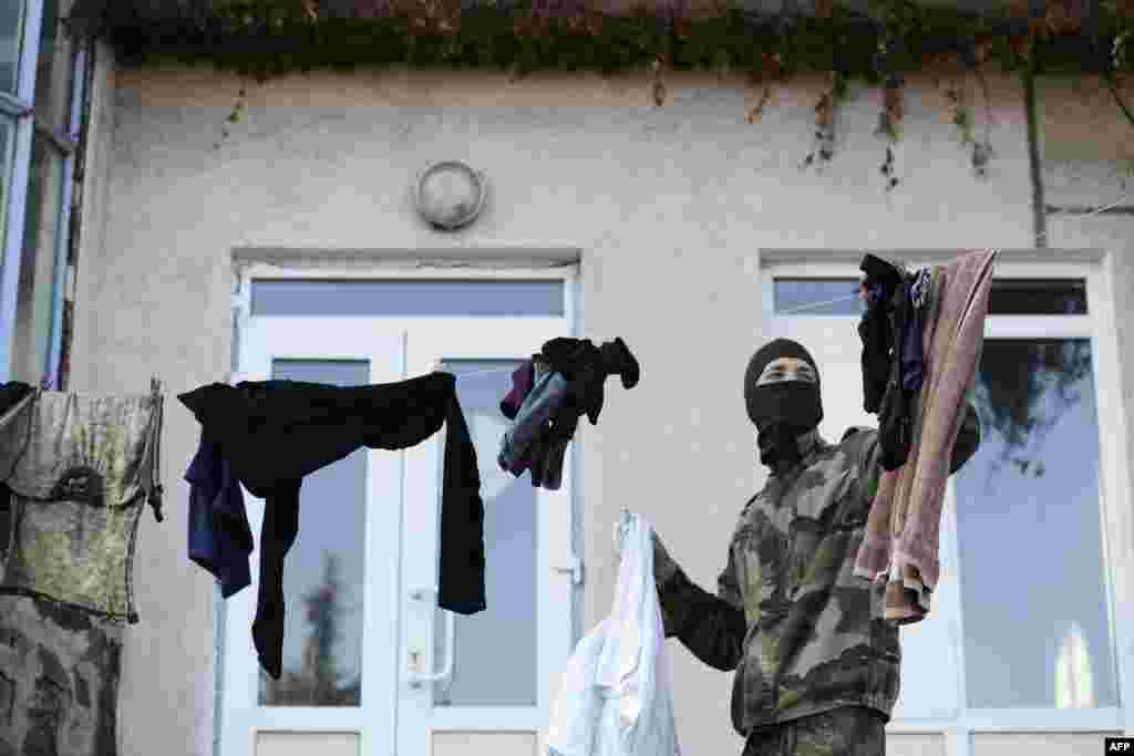 A serviceman of the pro-Ukrainian St. Maria Battalion hangs laundry at their base near the eastern city of Mariupol. (AFP/Alexander Khudoteply)