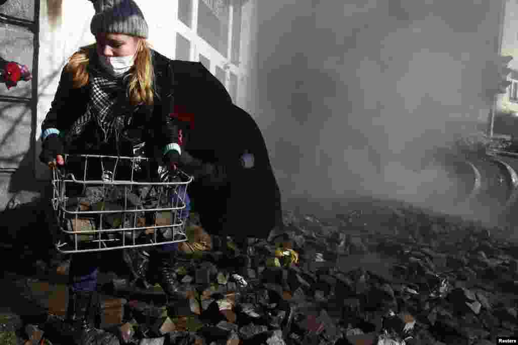 A woman carries stones during the violent clashes in Kyiv on February 18. (Reuters)
