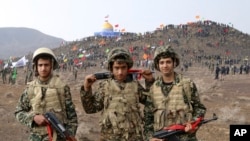 In this Friday, Nov. 20, 2015 photo released by the Fars News Agency, members of the Basij, the paramilitary unit of Iran's Revolutionary Guard, pose for a picture during a military exercise outside the holy city of Qom, central Iran. Thousands of paramil