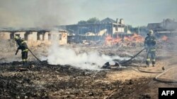 Zjarrfikës duke shuar zjarrin pas një sulmi rus në rajonin e Kievit, më 9 korrik 2025.