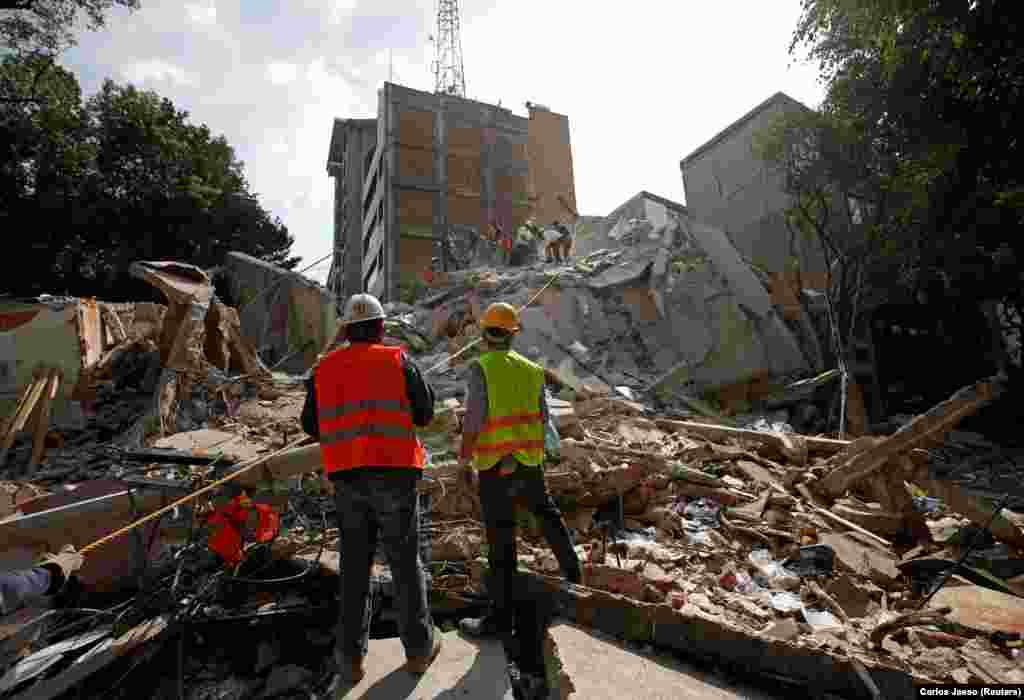 Ратаўнікі на руінах дома, разбуранага землятрусам у Мэхіка, 19 верасьня. (Reuters/Carlos Jasso)