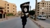 Боевик ИГ (ИГИЛ) с флагом этой организации, Ракка, Сирия