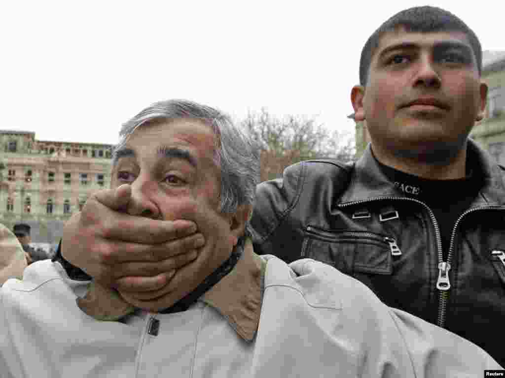 A plain-clothes policeman detains an opposition activist demanding freedom of speech during a rally in central Baku, Azerbaijan. Photo by David Mdzinarishvili for Reuters