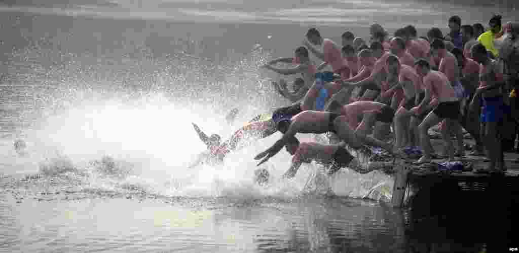 Men jump into icy lakewater to recover a wooden cross during Epiphany Day celebrations in Sofia, Bulgaria. (epa/Vassil Donev)