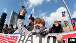 Женщина на митинге в Донецке с плакатом "НАТО руки прочь от Донбасса!"