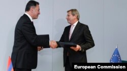 Belgium -- Armenian Economy Minister Karen Chshmaritian (L) with European Neighborhood Policy and Enlargement Negotiations Johannes Hahn during a signing ceremony in Brussels, November 3, 2014