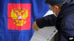 Russia - A man casts his ballot during parliamentary and local elections at a polling station in St. Petersburg, Russia, September 18, 2021. 