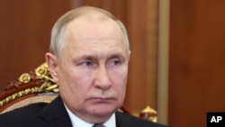 Președintele rus Vladimir Putin îl ascultă pe ministrul rus al apărării, Serghei Șoigu, în timpul unei întâlniri de la Kremlin, Moscova, Rusia, 17 aprilie 2023.