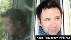 Opposition activist Ainur Qurmanov talks to reporters through the window of his hospital room in Almaty on May 2.