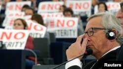 Pancarte cu inscripţia „Nu austerităţii" în Parlamentul European, în timpul votării lui Jean-Claude Juncker pentru funcţia de preşedinte al Comisiei Europene