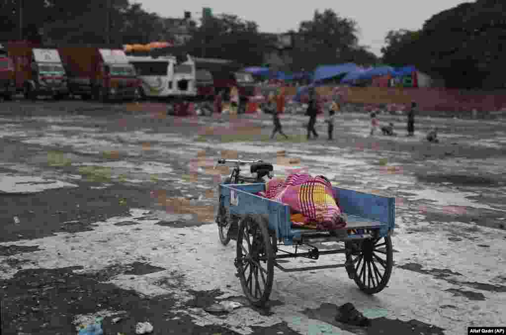 Рыкша сьпіць у сваёй павозцы, Індыя. (AP/Altaf Qadri)