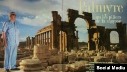 Ғалым Халед Асад Пальмира қаласының фонында тұрған плакат.