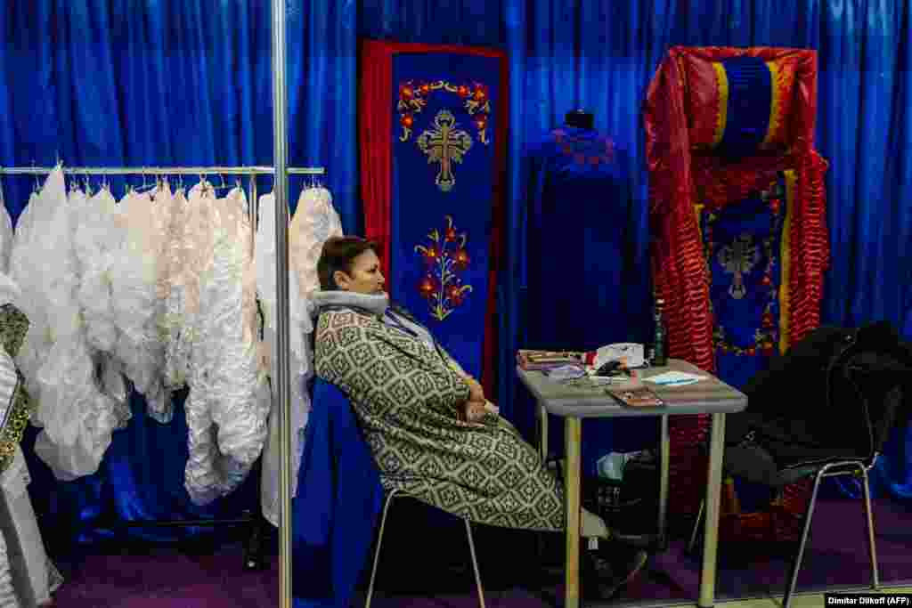 A participant sits at the stand of a coffin manufacturer during a funeral exhibition in the Russian capital, Moscow. (AFP/Dimitar Dilkoff)