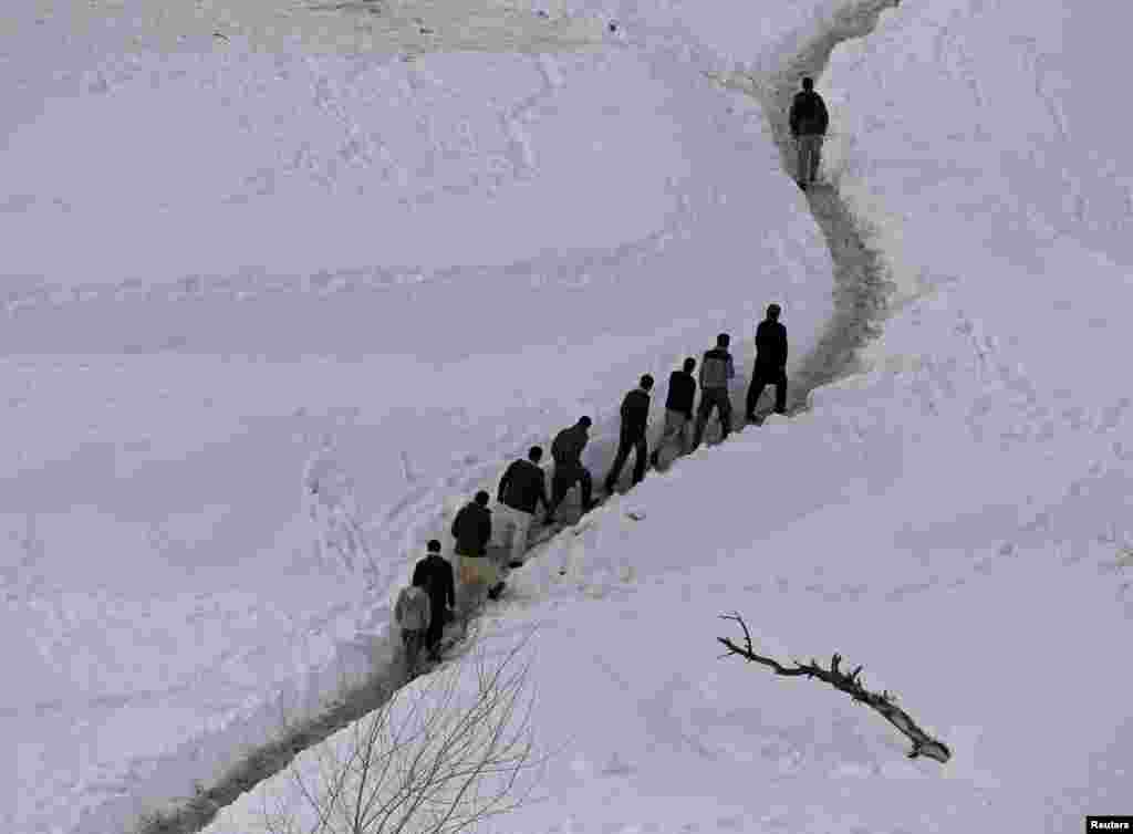 Survivors of an avalanche walk in the Abdullah Khil village of the Dara district of Panjshir Province in Afghanistan. (Reuters/Omar Sobhani)