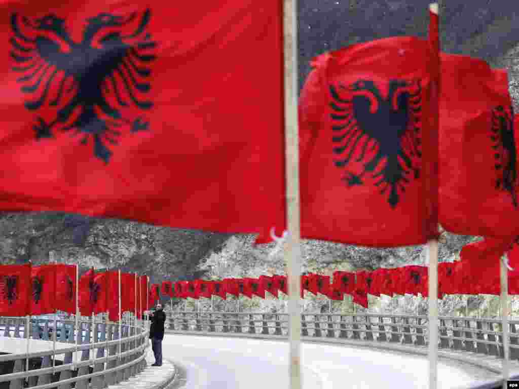A Kosovar man adjusts Albanian national flags in the town of Kacanik, southeast of Pristina, on February 15, as Kosovo prepared to celebrate the first anniversary of its declaration of independence from Serbia.