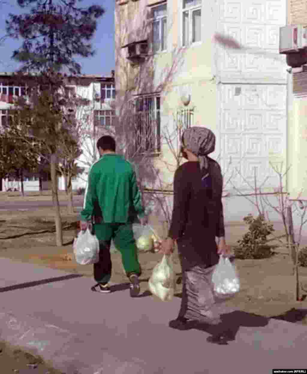 Azyk önümlerini alyp barýan şäher ýaşaýjylary. Aşgabat, mart, 2021 