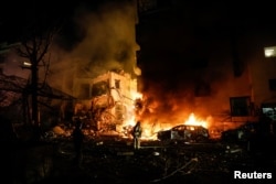 Israeli firefighters work to extinguish a fire on a car at the site of a projectile impact in Tel Aviv.