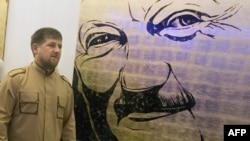 Разман Кадыров на фоне портрета Ахмата Кадырова (архивное фото)