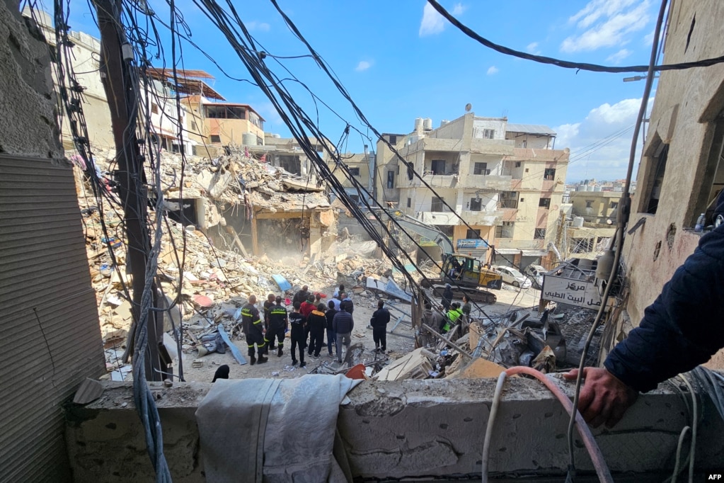 Punëtorët pastrojnë rrënojat në lagjen Bir Hasan në periferinë jugore të Bejrutit më 9 prill. Izraeli ka thënë se sulmet ndaj Hezbollahut nuk përfshihen në armëpushim, ndërkaq Irani ka argumentuar të kundërtën duke thënë se edhe Libani është pjesë e marrëveshjes.