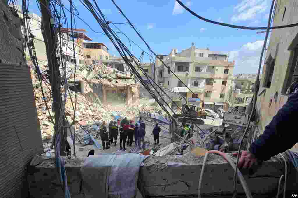 Workers clear rubble from the Bir Hassan neighborhood in Beirut's southern suburbs on April 9. Israel says strikes on Hezbollah are not covered by the cease-fire, while Tehran says the conflict with its Lebanon-based proxy is also part of the deal.