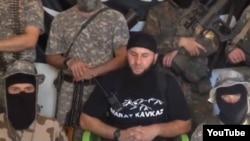 The address to North Caucasus Muslims is delivered by a wheelchair-bound fighter identified as Salakhuddin (center), who appears to have lost both legs.