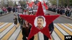 People carry a portrait of Soviet leader Josef Stalin during a march to celebrate the 72nd anniversary of the Soviet Union's victory over Nazi Germany in Sevastopol in Russian occupied Crimea on May 9, 2017,
