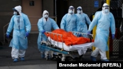 Медицинские работники везут каталку с телом умершего от осложнений, вызванных коронавирусом, Нью-Йорк, Бруклин, 4 апреля 2020 года