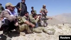 Members of the National Resistance Front observe from a hill in the Panjshir Valley.