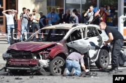 Ukrainian police examine the car in which Sheremet was traveling when he was killed.