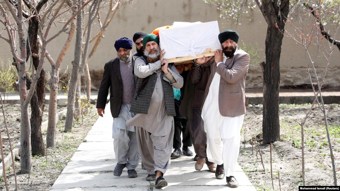 Afghan Sikh men carry a coffin at a funeral of one of the victims of an attack on a Sikh religious complex in Kabul in March 2020.