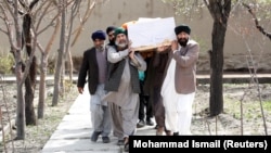 Afghan Sikh men carry a coffin at a funeral of one of the victims of an attack on a Sikh religious complex in Kabul in March 2020.