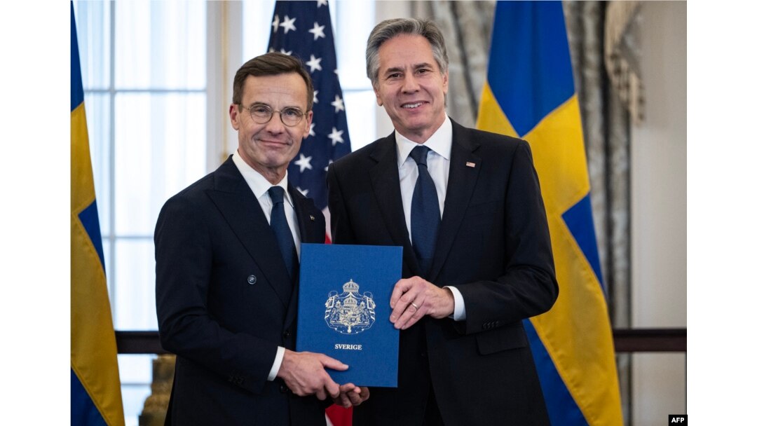 Premierul suedez Ulf Kristersson îi înmânează secretarului de stat american Antony Blinken documentele de ratificare pentru aderarea Suediei la NATO. Washington D.C., 7 martie.
