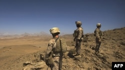 U.S. Marines stand on a hill after clearing through a cave while on patrol in Farah Province, Afghanistan, in 2009.
