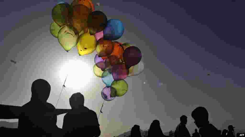 Afghan boys selling balloons wait for customers on the second day of Norouz celebrations in Kabul on March 21. (AFP/Shah Marai)