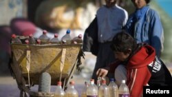Dječak prodaje naftu u bocama u blizini iransko-afganistanske granice, decembar 2009
