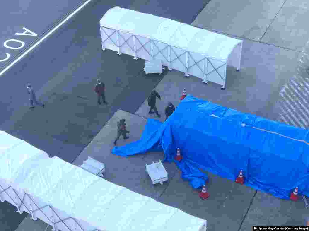 A gangplank being covered by a tarpaulin before dozens of infected passengers were evacuated from the vessel on February 10.&nbsp;While passengers still quarantined aboard the ship are kept informed and have been offered compensation, a crew member told RFE/RL that very little information had been given to the crew. Staff have not been told the names of infected colleagues removed from the vessel and isolated for medical treatment.