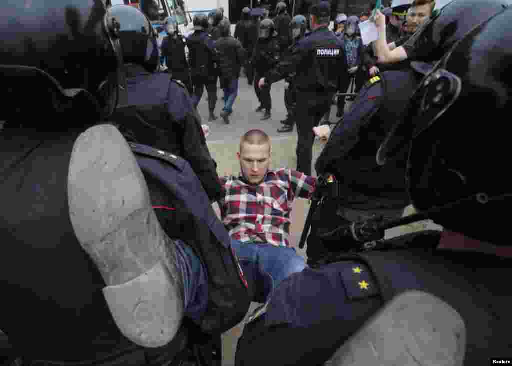 Петербург полициясының коррупцияға наразы азаматты ұстап, автобустарына апара жатқан сәті. 