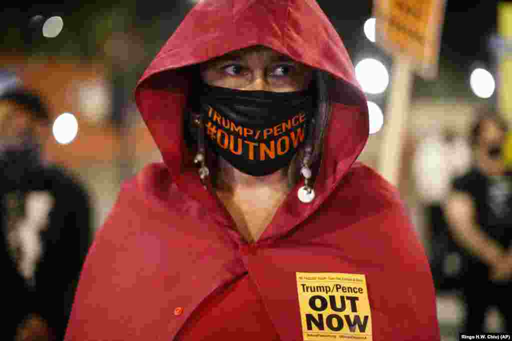 A woman wearing a face mask takes part in a protest in Los Angeles, Wednesday, Nov. 4, 2020.