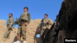 Afghan National Army (ANA) soldiers stand at an outpost in Helmand on December 20.