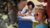 A young Ukrainian girl looks at a military serviceman taking part in the presidential election at a polling station in the city of Lviv.