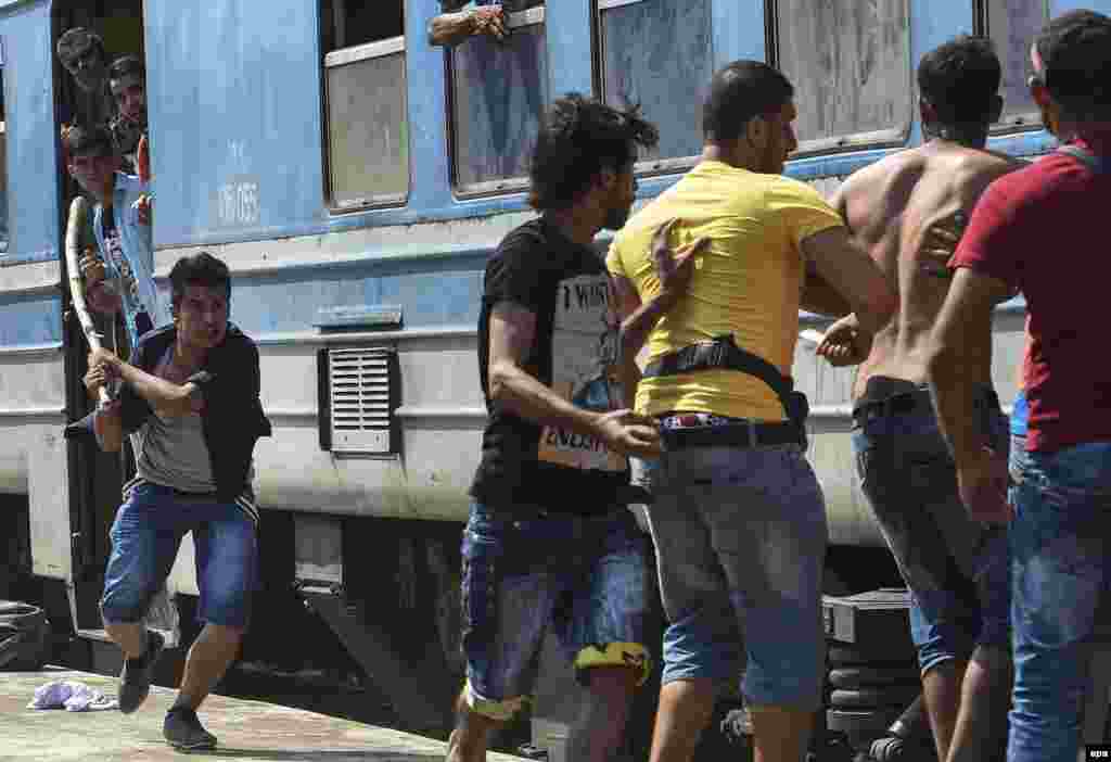 Migrants with sticks, stones, and knives fought after a brawl erupted over places in an overcrowded train heading to the Serbian border at the train station in Gevgelija, Macedonia. (epa/Georgi Livovski)