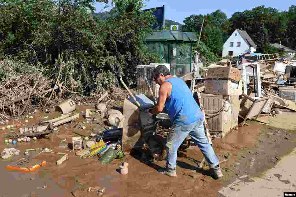 Мужчина разгружает завалы после наводнения, вызванного проливными дождями, в Зинциге, Германия, 18 июля 2021 года