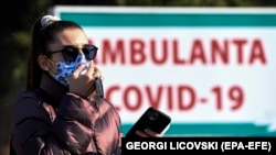 Një grua e veshur me një maskë mbrojtëse ecën para Klinikës Universitare për Sëmundje Infektive në Shkup, Maqedonia e Veriut, 04 Shkurt 2021.