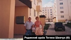 Тетяна Шевчук із сім'єю поряд із будинком, в якому їй надали службову квартиру, 2007 рік