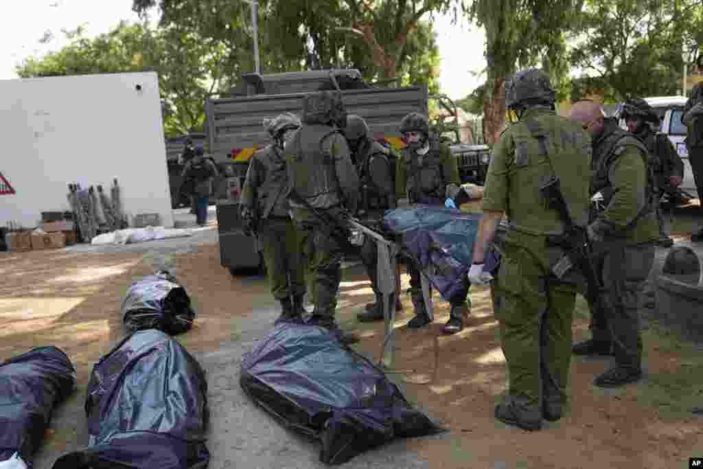 Israeli soldiers gather the bodies of civilians killed by Hamas militants at the Kibbutz Kfar Azza three days after the attacks.