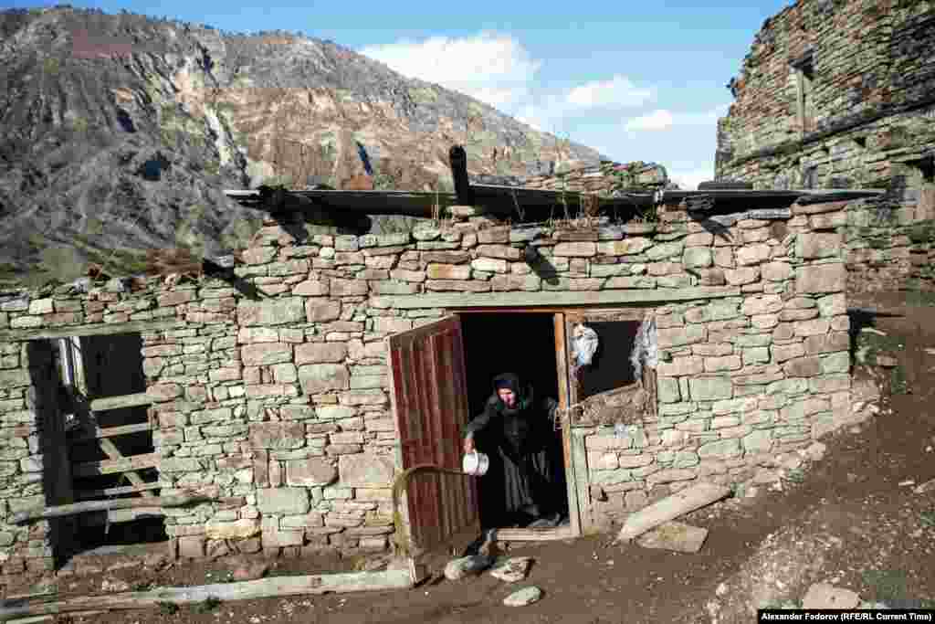 Patimat Musalmagomedova throws dirty water out of her house in Khyurdabakh, in the mountains of Daghestan. She is the last permanent resident of the village.