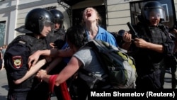 Police detain a young protester during an unsanctioned rally in Moscow on July 27. 