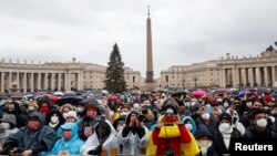 Люди слухають звернення папи Римського на площі біля собору Святого Петра у Ватикані. Рим, 25 грудня 2021 року