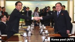 South Korea Unification Minister Cho Myung-gyon (left) shakes hands with North Korea's chief delegate, Ri Son Gwon during their meeting at the border truce village of Panmunjom in the Demilitarized Zone (DMZ) dividing the two Koreas on January 9.